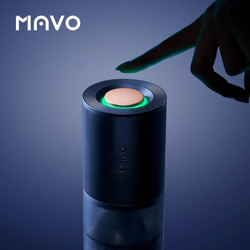 Finger pressing the one-touch start button on the MAVO Aurora grinder, ring light glowing green