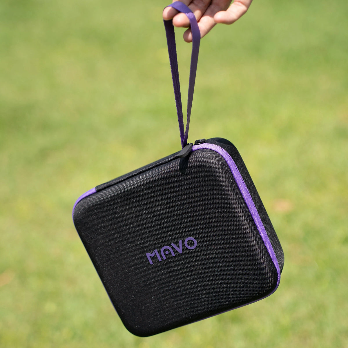 MAVO Aurora hard carrying case with purple zip and wrist strap, carried outdoors