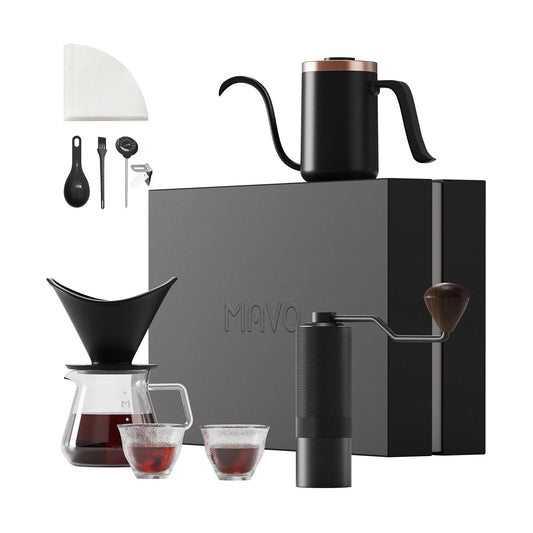 MAVO Pour Over Coffee Set in Black: gooseneck kettle, winged ceramic dripper on a glass server, Wizard hand grinder, two tasting cups, thermometer, spoon and filter papers in front of the gift box
