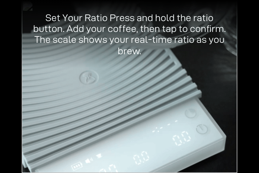 Set Your Ratio: a server on the white Basic 3 while the display shows the live ratio — 'Press and hold the ratio button. Add your coffee, then tap to confirm. The scale shows your real-time ratio as you brew.'