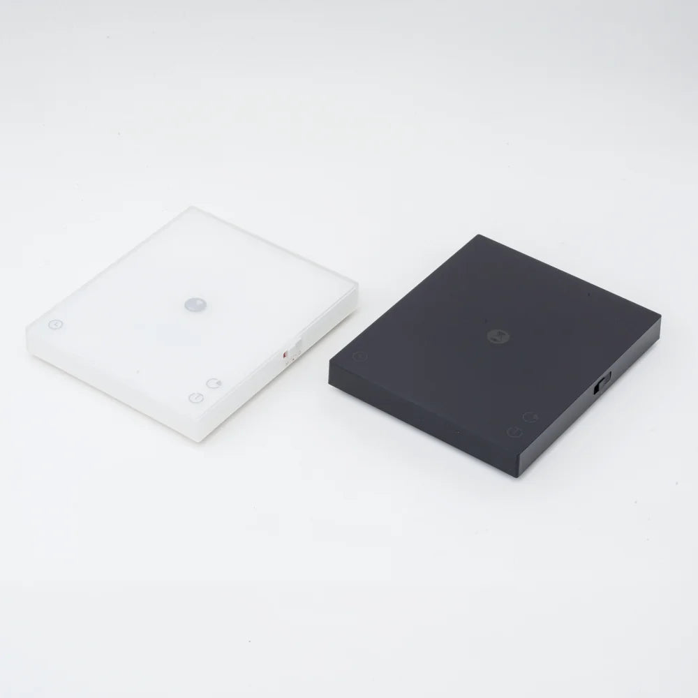 White and black TIMEMORE Basic 3 scales side by side with their mats removed, showing both colourways of the slim chassis