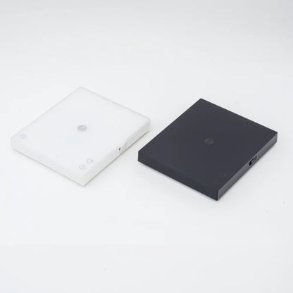 White and black TIMEMORE Basic 3 scales side by side with their mats removed, showing both colourways of the slim chassis