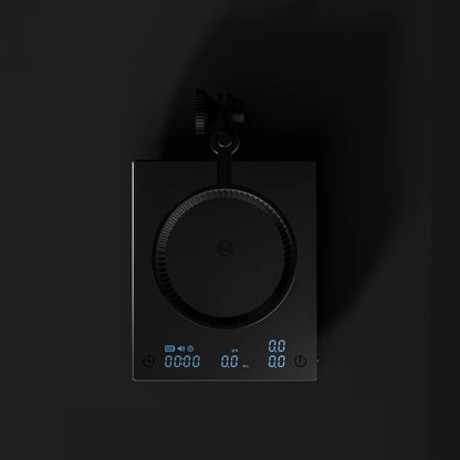 Top view of the DUO with the dripper ring swung over the scale and the display glowing at the front