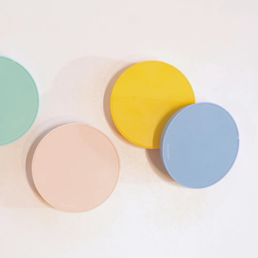 Flat lay of yellow, blue, pink and green TIMEMORE Dot discs overlapping on a white surface