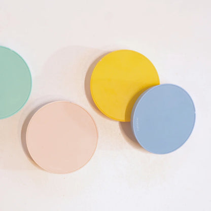 Flat lay of yellow, blue, pink and green TIMEMORE Dot discs overlapping on a white surface