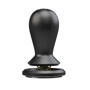 Black TIMEMORE × Anthony Douglas FLOW self-leveling tamper standing upright on a white background, with a black teardrop handle, tapered collar, gold wave spring and a 58.5mm black base