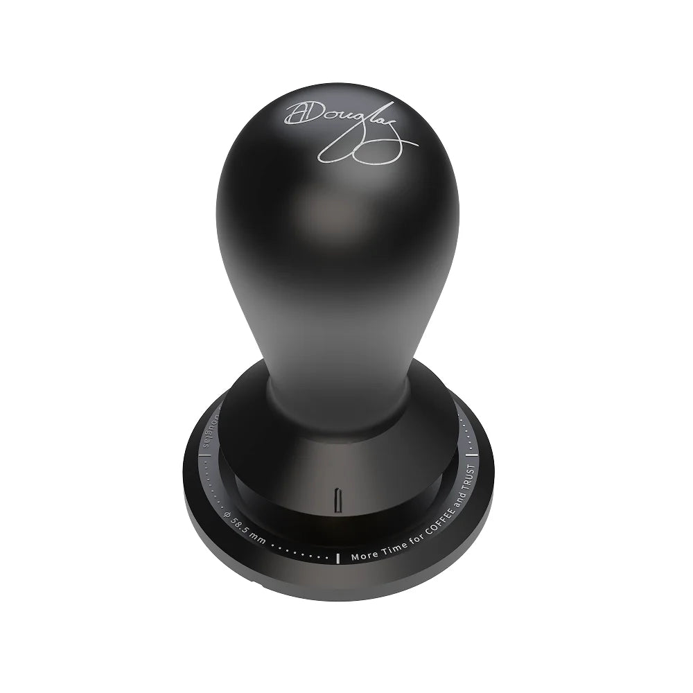 Black FLOW tamper seen from above at an angle, the teardrop handle engraved with Anthony Douglas's signature and a ring of engraved text around the base