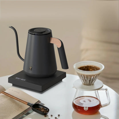 TIMEMORE Fish Pro X kettle beside a pour over dripper and glass server of filter coffee on a light worktop