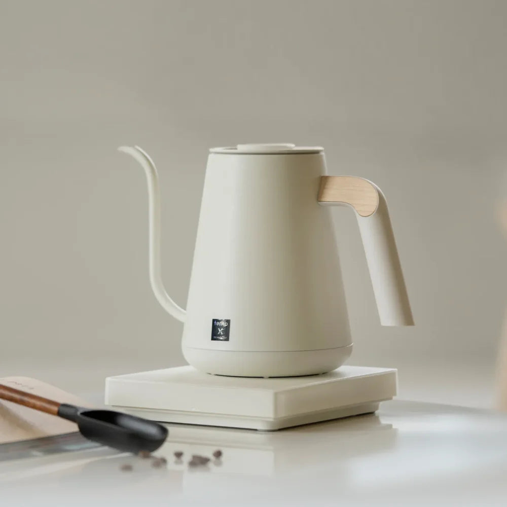 TIMEMORE Fish Pro X kettle styled with a dripper, glass server and coffee scoop on a linen-toned worktop