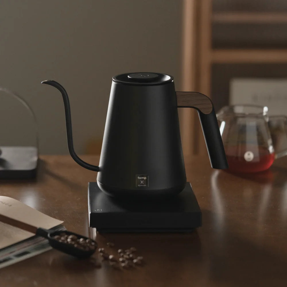 TIMEMORE Fish Pro X kettle on a walnut table beside a glass server of filter coffee and whole beans