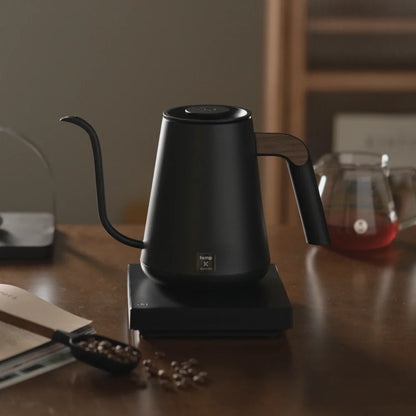 TIMEMORE Fish Pro X kettle on a walnut table beside a glass server of filter coffee and whole beans