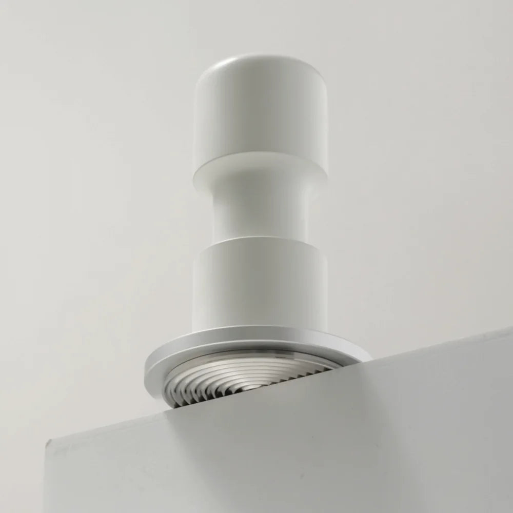 White Impulse Impact Tamper on the edge of a pale shelf with its concentric ripple base facing the camera