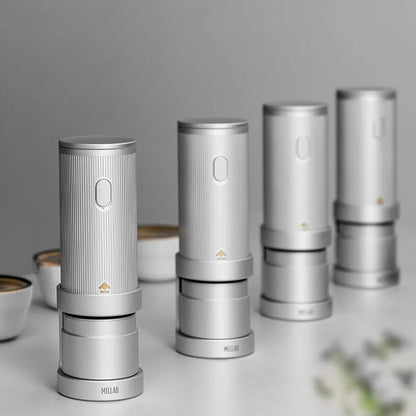 Four TIMEMORE x MILLAB E01 grinders lined up on a coffee cupping table