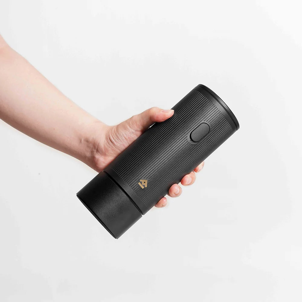 Hand holding the TIMEMORE x MILLAB E01 grinder body sideways to show its compact 72 mm diameter