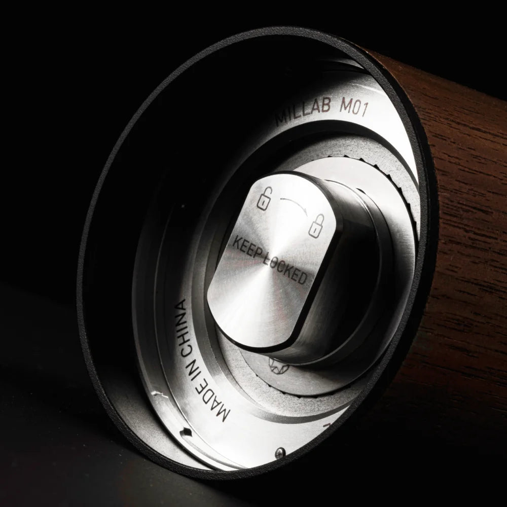 Low-light view into the base of the walnut M01 with the catch cup off, showing the Keep Locked swivel-lock coupling