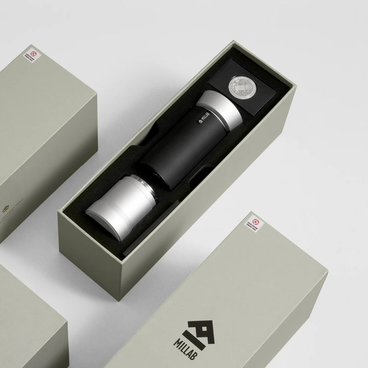 The Silver TIMEMORE x MILLAB M01 in its open presentation box with the commemorative coin, next to the MILLAB-branded outer sleeve
