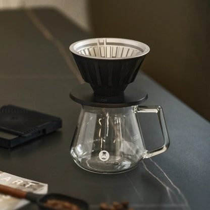 TIMEMORE VECTOR dripper on a glass server beside a coffee scale on a dark stone counter
