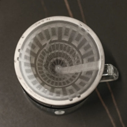 Top view of the VECTOR dripper with a white 01 paper filter seated against the lattice, on a glass server