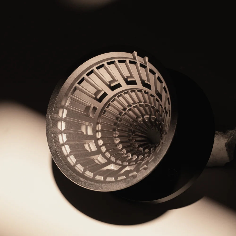 Close-up of the VECTOR dripper's stainless steel interior ribs in warm side light
