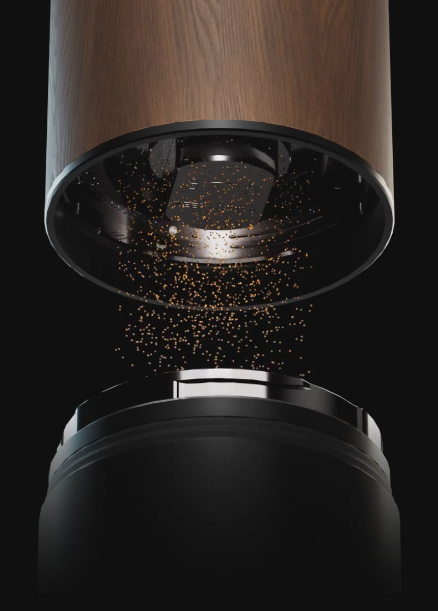 Animated close-up of the walnut M01 with the catch cup lowered, coffee particles falling evenly from the Pineapple Burr into the cup