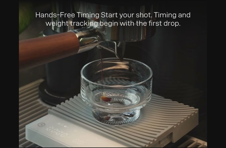 Hands-Free Timing: espresso pouring into a glass on the Basic 3 — 'Start your shot. Timing and weight tracking begin with the first drop.'